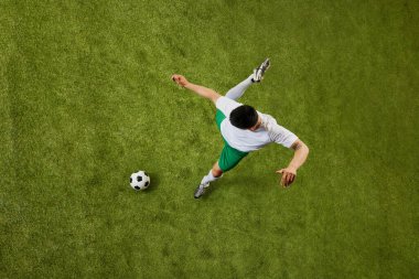 Genç atletik adamın kuş bakışı görüntüsü, futbol oyuncusu sahada oyunu değiştirmeye hazır. Profesyonel spor, rekabet, turnuva, enerji, aksiyon kavramı. Ad