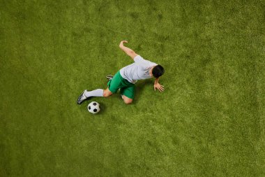 Yeşil şortlu ve beyaz formalı bir sporcunun yeşil sahada topa vuruşunun genel görüntüsü. Profesyonel spor, rekabet, turnuva, enerji, aksiyon kavramı. Ad