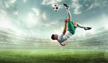 Profesyonel futbol atletinin el fenerleriyle stadyumda hareketli dinamik sinematik çekimi, kazanmak için topu havada tekmeliyor. Profesyonel spor konsepti, şampiyonluk, turnuva, maç.