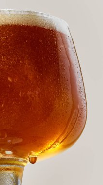 Zengin, kehribar, bira bardağını gri stüdyonun arka planına yakın çekim. Kupa alkollü içecekle dolu. Yiyecek ve içecek kavramı, kutlama, Ekim festivali, içecek endüstrisi. Ad