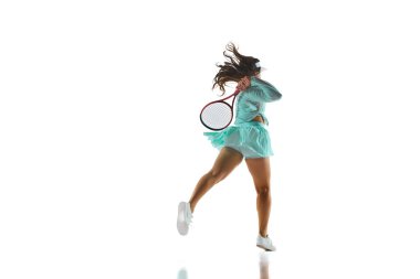 Açık mavi tenis elbisesi içinde beyaz stüdyo arka planında raketiyle greve hazır bayan sporcunun arka plan fotoğrafı. Profesyonel spor konsepti, şampiyonluk, turnuva. Ad