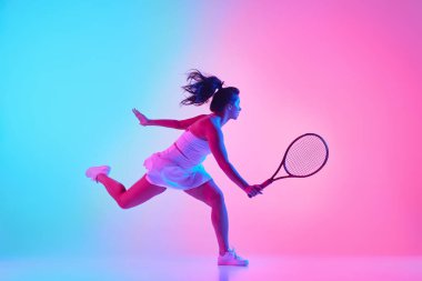 Beyaz elbiseli bayan sporcu, parlak ışık altında güçlü bir atış yapmak için raketini sallıyor. Profesyonel spor konsepti, şampiyonluk, turnuva. Ad