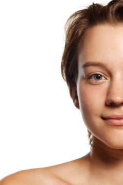 Bir kadının yüzüne yakın çekim, bir gözüne ve gülüşüne odaklanma, temiz cildine ve doğal güzelliğine dikkat çekme. Gençlik kavramı, güzellik ve moda, kozmetik ürünler, dermatoloji. Ad