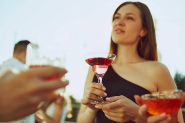 Dostlar bardaklarını tokuştururken, sıcaklığın ve arkadaşlığın tadını çıkarırken kutlama havası havayı dolduruyor. Parti açık havada. Parti anlayışı, Cuma havası, kutlama, yaz tatili, rahatlama.