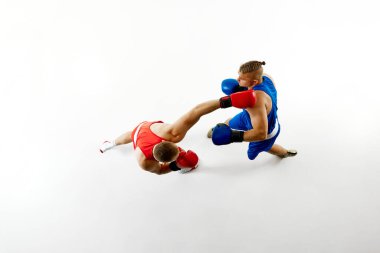 Boks maçının hava görüntüsü, kırmızı giyimli boksör tarafından mavi giyinmiş boksöre atılan yumruklar beyaz stüdyo arka planına karşı. Profesyonel dövüş sporu kavramı, sağlıklı yaşam tarzı, rekabet. Ad