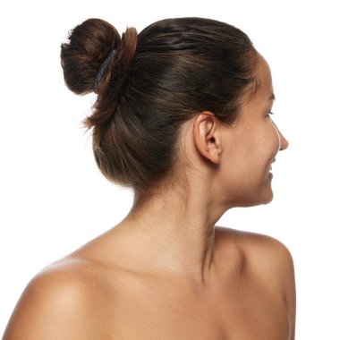 Çıplak omuzlu bir kadının profil görüntüsü beyaz stüdyo geçmişine bakıyor. İyi korunmuş ciltli bir model. Yüz bakımı, kaldırma, spa prosedürleri, ameliyat kavramı.