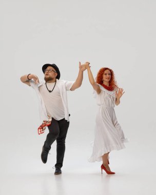 Tutkulu salsa ikilisi dans hareketlerini mükemmelleştirir, beyaz stüdyo arka planına karşı, ritim ve koordinasyona odaklanırlar. Dans sınıfı kavramı, müzik, yaşam tarzı, hobi, sanat, dans okulu, yetenek.