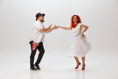 Salsa ikilisi, erkek ve kadın, beyaz stüdyo geçmişine karşı özenle pratik yapar, karmaşık adımlarda ve hareketlerde ustalaşır. Dans sınıfı kavramı, hobi, sanat, dans okulu, yetenek..