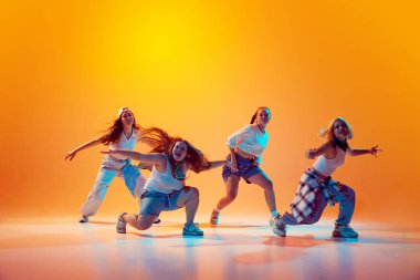 Stüdyonun arka planında canlı neon ışıklarıyla dans eden kızlar. Dinamik dans stili. Müzik, moda ve sanat kavramı, retro ve modernite, hareket, spor ve hobi. Ad