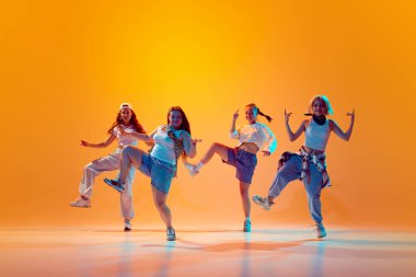 Genç enerjik kadın kuartetinin dinamik fotoğrafı gradyan stüdyo arka planına karşı canlı neon ışıkta performans sergiliyor. Müzik, moda ve sanat kavramı, retro ve modernite, hareket, spor ve hobi.