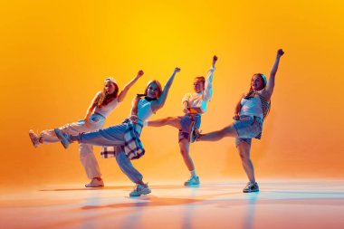 Bir grup bayan dansçı, eski moda elbiseli arkadaşlar hareketli neon ışıklarıyla dans ediyorlar. Gradyan stüdyo arka planında. Müzik, moda ve sanat, spor ve hobi kavramı. Ad