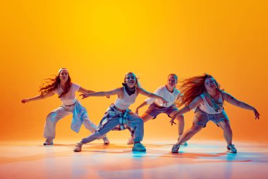 Vay canına. Bir grup enerjik, duygusal dansçı, gradyan stüdyo arka planına karşı canlı neon ışığı altında hip-hop hareketleri yapıyorlar. Müzik, moda ve sanat kavramı, retro ve modernite, hareket.