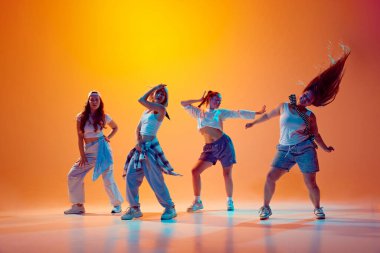 Artistik kızlar grubu, serbest stilde dans eden dansçılar, eski moda kıyafetleri giymiş, neon ışıklarıyla hareket eden gradyan arka planda. Müzik, moda ve sanat kavramı, modernlik, hareket. Ad