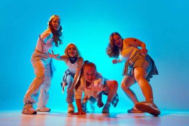 Günlük giysiler içindeki dansçılar dinamik ve anlamlı pozlar veriyorlar. Enerjik ve eğlenceli kişiliklerini, parlak neon ışıklarıyla, gradyan stüdyonun arka planına karşı gösteriyorlar. Müzik, retro ve modernlik kavramı