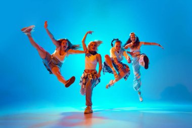 Dört dansçı coşkulu ve dinamik pozlarla hareketli neon ışıklarıyla gradyan stüdyonun arka planına sıçrıyor. Müzik, moda ve sanat kavramı, retro ve modernite, hareket, spor ve hobi.