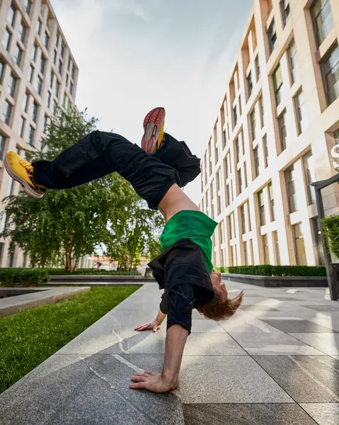 stock image Parkrun lover in action, standing on hands against city backdrop, embodying joy and energy of participating in parkrun. Concept of lifestyle, extreme sport, freestyle, activity, motion. Ad