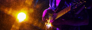 Banner. Musicians hand strums guitar, highlighted by electric blue and purple lights, creating vivid scene of musical passion. Concept of music and party, hobby and work, energy, music festivals. Ad clipart