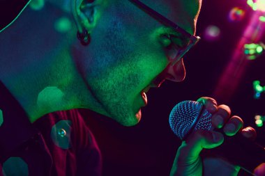 Vokalistlerin yüzü, neon ışıklarının altında parlayan, canlı müziğin ham duygu ve enerjisini tüm detaylarıyla görünür kılıyor. Müzik ve parti kavramı, hobi ve iş, enerji, festivaller. Ad