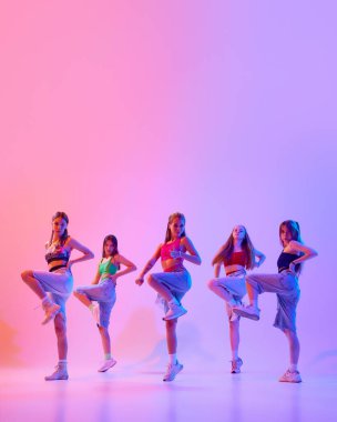 Poster. Yetenekli genç kızların dinamik portresi, neon ışıkta, gradyan pembe arka planda dans ediyorlar. Uzayı kopyala Spor ve hobi kavramı, çocukluk, arkadaşlık, hareket. Dans okulu.