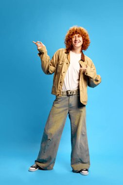 Eski tarz giyinmiş neşeli genç adam mavi stüdyo arka planına karşı yan yana duruyor. Boşluk yok. Kara Cuma kavramı, Siber Pazartesi, moda, hızlı satış. Ad