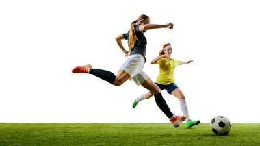 Genç bayan futbolcu, güçlü bir tekme atarken rakip, hem canlı yeşil sahada, hem de maçta her şeylerini ortaya koyuyor. Spor, yarışma, turnuva, oyun, etkinlik kavramı.