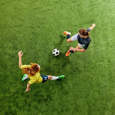 20 'li yaşlarının başında, futbol sahasında çarpışan atletik kadınlar, her ikisi de sahip olma savaşını kazanmaya kararlı. Hava görüntüsü. Spor, yarışma, turnuva, oyun, etkinlik kavramı.