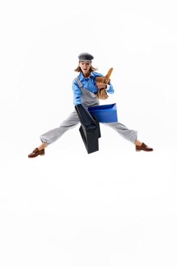 Neşeli bir ifadeyle orta sıçrayışta, kadın çantalarını ve baget ekmeğini beyaz arka planda tutar, alışveriş ve günlük işlerle harmanlar. Alışveriş anlayışı, Kara Cuma, moda ve tarz, satış. Ad