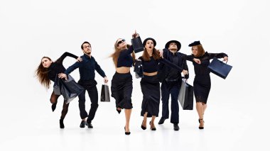 Grup, beyaz stüdyo arka planına karşı önemli bir şeye doğru ilerliyormuş gibi. Alışveriş anlayışı, Kara Cuma, moda ve tarz, satış sezonu. Ad