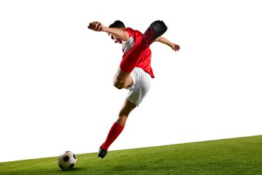 Kırmızı-beyaz üniformalı futbolcu, güçlü bir tekme atarken orta atlama, beyaz stüdyo arka planıyla yeşil sahada egzersiz yapıyor. Şampiyonluk konsepti, spor müsabakaları, final maçı. Ad