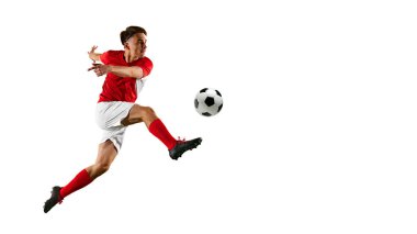 Genç futbolcu, kırmızı-beyaz üniforma giyiyor, dinamik bir tekmeyle beyaz stüdyo arkaplanına negatif alan yaratıyor. Şampiyonluk konsepti, spor müsabakaları, final maçı. Ad