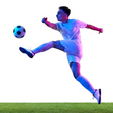 Antrenman sırasında parlak neon ışığı altında odaklanmış futbolcu, havadaki topu kontrol etme üzerinde çalışarak atletizmi gösteriyor. Şampiyonluk konsepti, spor müsabakaları, final maçı. Ad