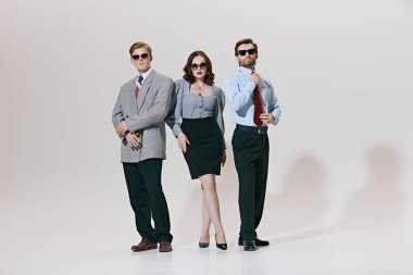 İktidarı kıvrımlı bir şekilde kucaklayan bu profesyoneller, özel dikim takım elbiseler ve güneş gözlüklü şık etekler, iş otoritesini ve yüksek moda tarzını harmanlıyorlar. İş ve tarz kavramı, liderlik.