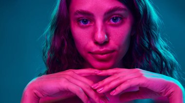 Canlı renklerin yüz hatlarını ve pürüzsüz cildi ön plana çıkardığı, dermatolojiyi yüksek moda görsellerle birleştirdiği sakin ama yoğun bir görünüş. Güzellik, moda, görünüş, özgüven kavramı. Ad