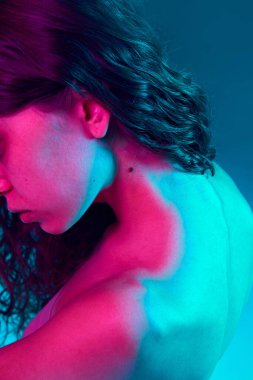 Arkaya ve omuza yakın çekim, cildin doğal dokusuna canlı neon ışıkla odaklanma, cilt bakımı ya da moda için mükemmel. Güzellik, moda, görünüş, özgüven kavramı. Ad