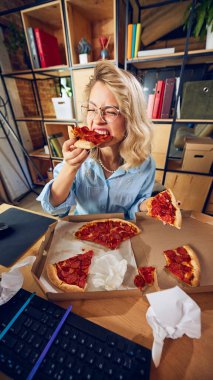 Pizza dilimlerini ısıran işçilerin yakın çekimi, açıkça dikkati dağılıyor. Çalışma saatlerinde yemek yemek düzensizlik ve profesyonel olmayan davranışları gösterir. Günlük iş sorunları kavramı. Ad.