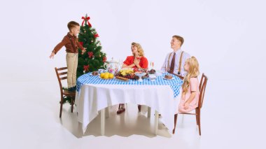 Çocuk sandalyeye çıkıp Noel ağacının yanında şarkı söylerken ailesi izliyor ve gülümsüyor. Tatil ruhu, süslerle ve ziyafetlerle dolu. Noel kavramı, aile, kutlama