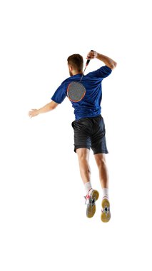 Sporcu raketini geri sallıyor, tam da top oynamaya hazırlanıyor. Yoğunluğu, badmintonun rekabetçi doğasının üst seviyesini vurguluyor. Rekabet kavramı, atletik performans, spor, oyun. Ad