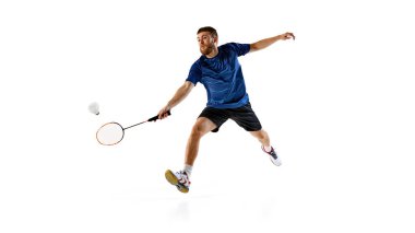 Erkek oyuncu, beyaz arka planda tam isabetli bir vuruş yapmak için elini uzatır. Oyuna girerken hızlı refleksleri ve çevikliği. Profesyonel spor, hareket, hareket kavramı. Ad