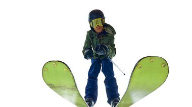 Aşağıdan, erkek kayakçının tam teçhizatlı şekilde eğilip beyaz stüdyo arka planına karşı maksimum hız hedeflediği yere bakın. Aşırı kış sporları, tatil, tatiller, hız, eğlence kavramı. Ad