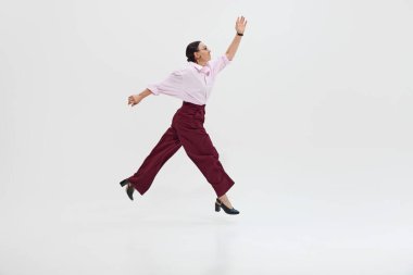 Sıradan giyimli son sınıf öğrencisi, beyaz stüdyo geçmişine karşı bireysellik ve yaratıcılık göstererek kararlı bir bakışla öne atlıyor. DEI kavramı, iş, ortaklık, çalışma, destek ve birlik.