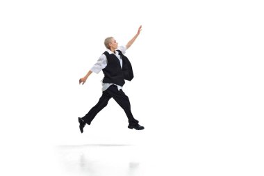 Sıradan giyimli genç bir kadın kararlı bir bakışla öne atlıyor, beyaz stüdyo geçmişine karşı bireysellik ve yaratıcılık gösteriyor. DEI kavramı, iş, ortaklık, çalışma, destek ve birlik.