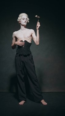 Soluk benizli, dramatik duruşu olan, opera camı tutan ve klasik zarafeti modern minimalizmle karıştıran bir adam. Füzyon ve modern sanat, müzik ve parti kavramı, bale. Ad