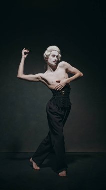 Genç adam bale öğeleriyle tarihi yetenekleri birleştiriyor, eski ve yeni dünyaları zarif bir şekilde birbirine bağlıyor. Klasik arka plan. Modern ve klasik, sanat, müzik ve parti, bale kavramı. Ad