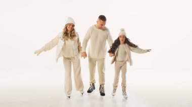 Aile, buz pateni pistinde vakit geçirmeyi, gülümsemeyi ve el ele tutuşmayı, kış sezonunda beyaz arka planda kaliteli zaman geçirmenin keyfini çıkartıyor. Kış tatili kavramı, Noel tatili.