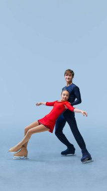 Patenciler buzda kaldırma gösterisi yapıyor. Bir çift artistik patinajcı, buz dansı sırasında soğuk mavi arka planda akrobatik kaldırışı gösteriyor. Kış sporu, zarafet ve zarafet kavramı, şampiyonluk. Ad