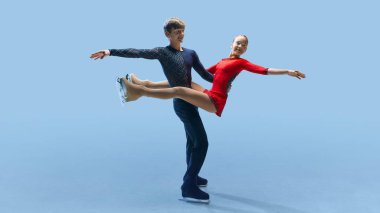 Buz üzerindeki performansları sırasında buz mavisi zemine karşı dengeli kaldırış sergileyen iki artistik patinajcı. Kış sporu, zarafet ve zarafet kavramı, şampiyonluk. Ad