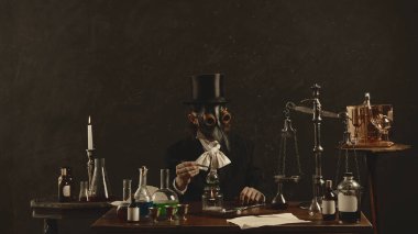 Ortaçağ insanı, veba doktoru vintage laboratuarında masada oturuyor ve araştırma sonuçlarına dikkat çekiyor, karanlık gizem geçmişine karşı fikirler. Tıp, bilim, eczacılık kavramı. Ad