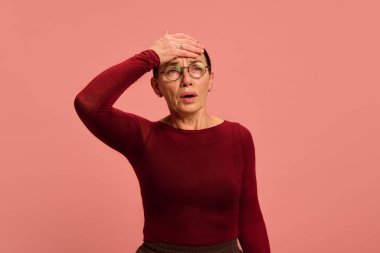 Emekli, el ele tutuşan bir kadın, pastel şeftali arka planda acı hissediyor. Belirtiler ve tedaviler. Stres yüzünden. Sağlık sigortası, tedavi, önleme kavramı. Ad