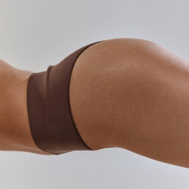 Yakın çekim, yumuşak deri dokusunu ve uyumlu formu yakalar. Vücut hatları, fitness adanmışlığı ve kendini ifade etme özgüveni. Doğal güzellik, kadın sağlığı, moda ve tarz kavramı. Ad