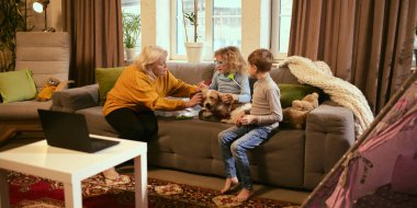 Büyükannem köpeğe tıbbi aletlerle kulaklarını kontrol etmesi için rehberlik eder. Diğerlerine bakmayı öğretir. İzler, sorumluluk ve sağlık konularını öğrenir. Tıp hakkında bilgi kavramı.